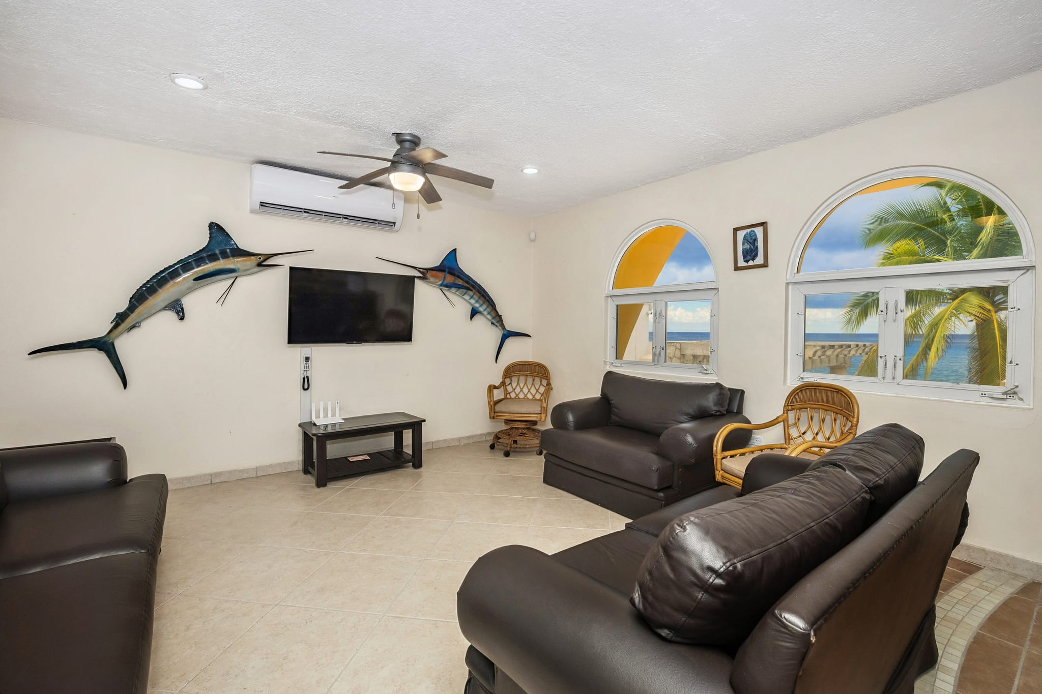 Living room with mounted marlins and ocean-view windows