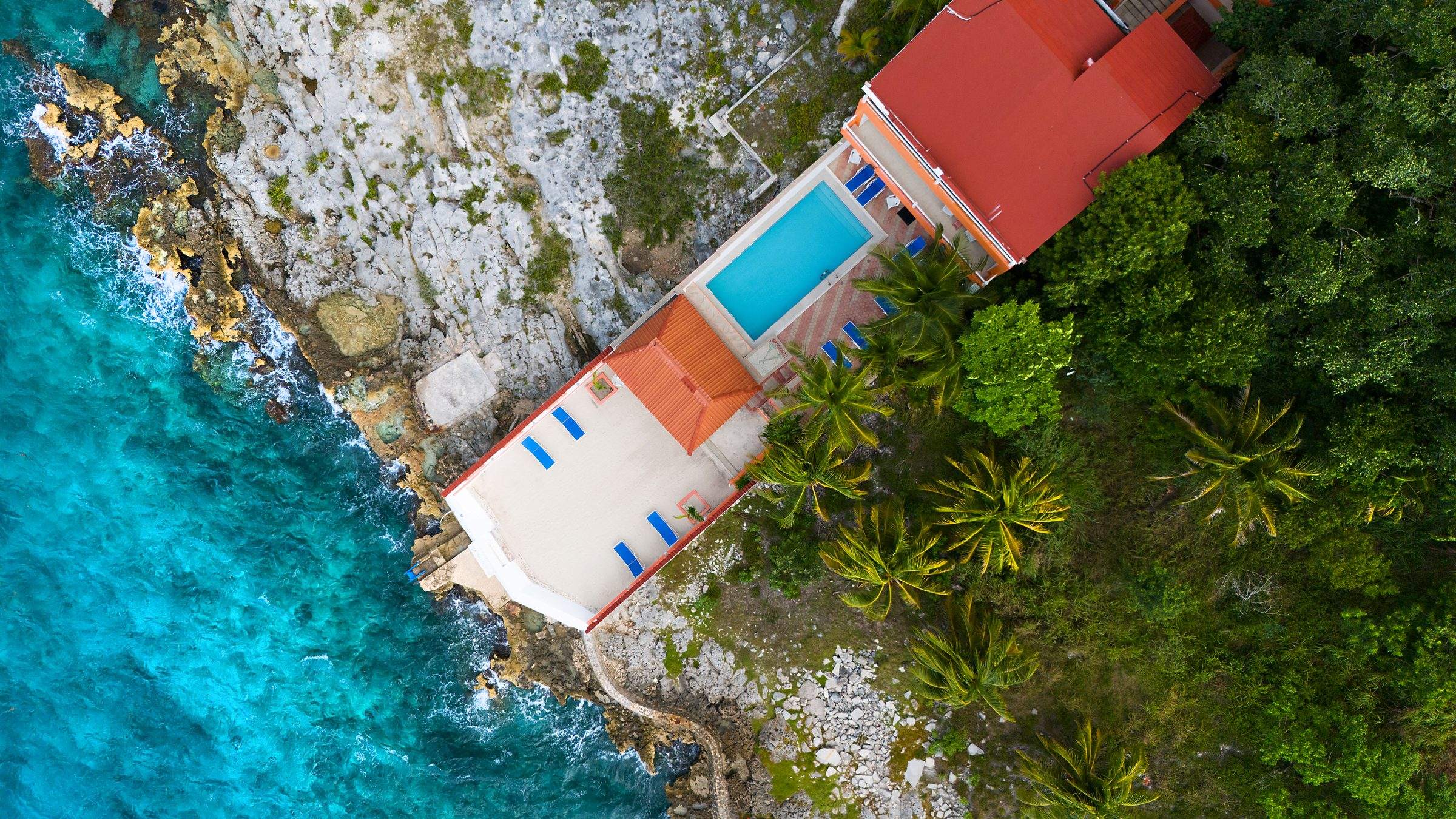 An Island Casa home and pool above the water, from the air