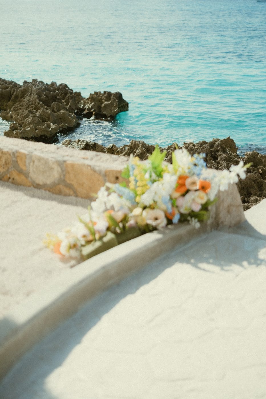 A three-tier cake on a side table above the water