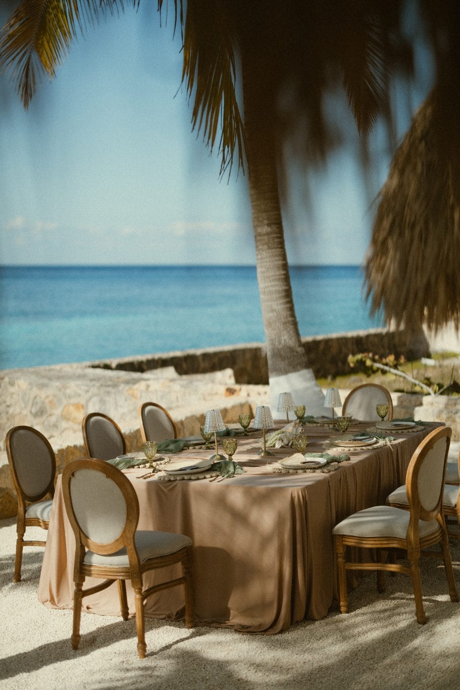 Two palapas and a set table facing open water